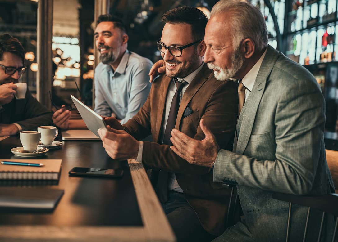 Image - Business men having coffee and looking at a tablet