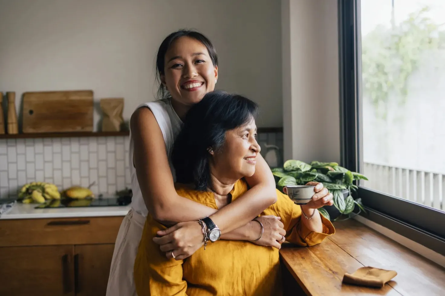 Daughter hugging her mother in a kitchen