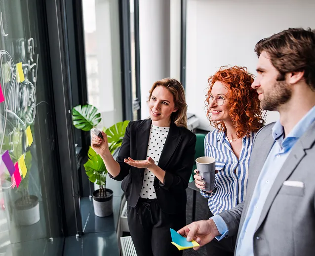 Three people strategising around a board