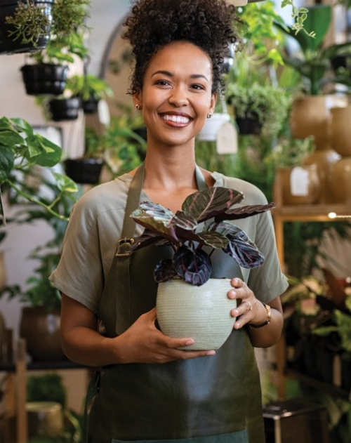 Lady holds plant in plant shop